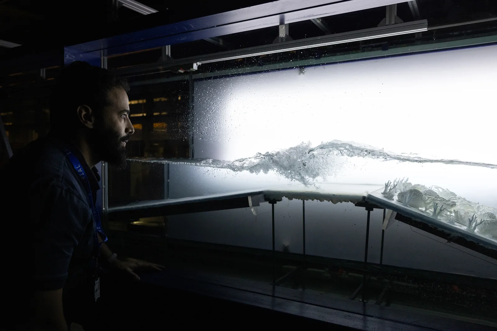 Yusuf Radad observing a breaking wave in a hydrodynamics laboratory wave tank
